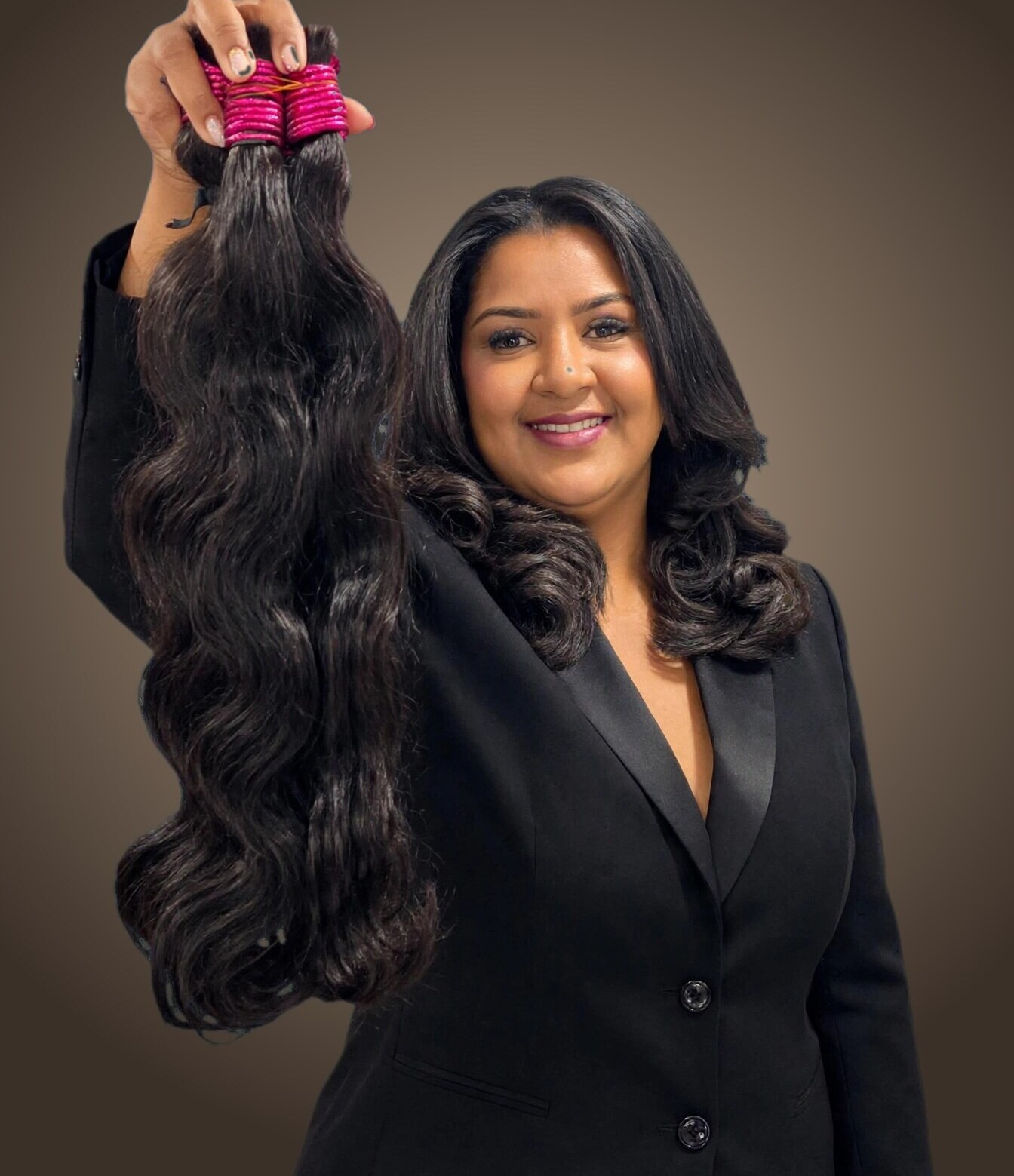 Érica, da ÉRICA HAIR STORE, segurando cabelo humano ondulado